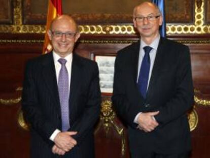 El ministro de Hacienda, Cristóbal Montoro (i), posa junto al comisario europeo de Programación Financiera y Presupuestos, Janusz Lewandowski, momentos antes de la reunión que ambos han mantenido hoy en la sede del ministerio, en Madrid.