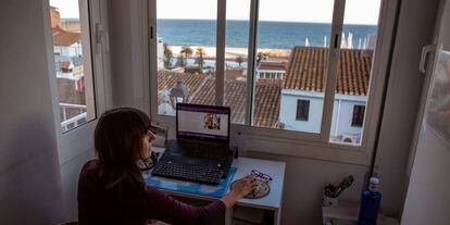 Una mujer teletrabaja en una estancia de su casa.