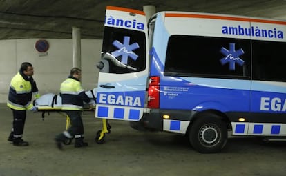 Dos sanitaris al costat d'una ambulància a Terrassa.