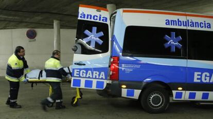 Dos sanitaris al costat d'una ambulància a Terrassa.