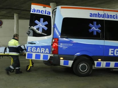 Dos sanitaris al costat d'una ambulància a Terrassa.