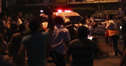 Unos palestinos transportan a un polic&iacute;a a una ambulancia despu&eacute;s de una carga contra los manifestantes.