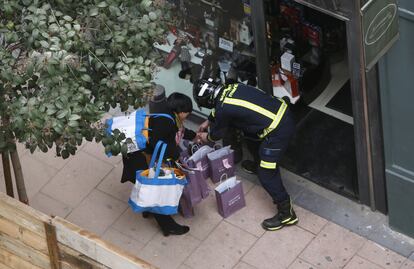 La policía ayuda a los comerciantes de la zona a desalojar sus negocios.