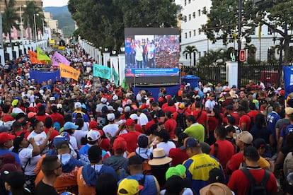 Una multitud se congrega cerca de una pantalla para ver a Nicolás Maduro dar un discurso a sus seguidores.