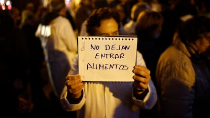 Una doctora muestra un cartel ante la Consejería de Sanidad de Madrid durante el encierro del comité de huelga.