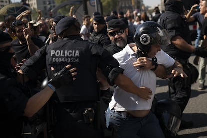 A pro-independence protester tries to break police lines.