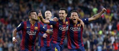 Rafinha, Xavi y Adriano festejan un gol.