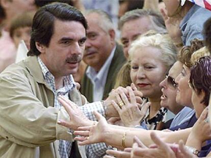 Aznar saluda a algunos de los asistentes al acto de su partidoen la plaza de toros de Zaragoza.