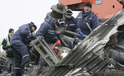 Trabalhadores retiram restos da fuselagem do avião em Grabovo.