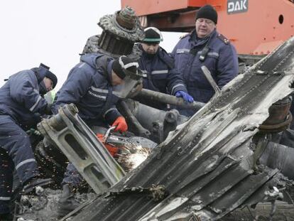 Trabalhadores retiram restos da fuselagem do avião em Grabovo.