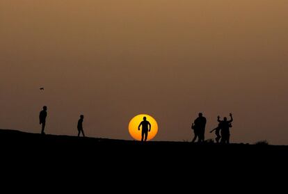 Niños palestinos juegan durante la puesta del sol en el campamento de refugiados de Khan Younis, al sur de la Franja de Gaza.