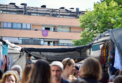 Desde el mercadillo de Majadahonda, se divisa en una lona morada con un mensaje de protesta: "No a la ampliación del mercadillo".