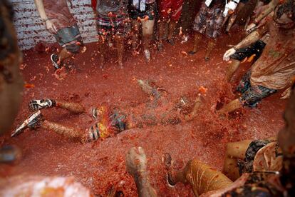 Participante en la fiesta La Tomatina tendido en el suelo.