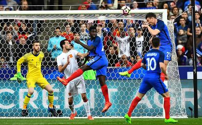 El defensa de la selección de Francia Laurent Koscielny (derecha) golpea el balón de cabeza en la porteria de España.