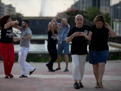 Diego Reberdito y Rosa García, en primer término, bailan bachata en el bautizado como Parke del baile BLM en Vallecas (Madrid).