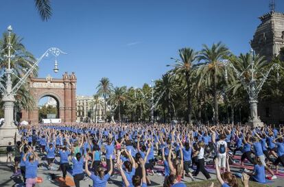 Cerca de 2.000 'yoguis' se reúnen en el Arc de Triomf en Barcelona para practicar esta disciplina.