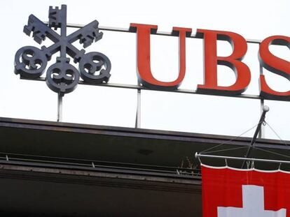 Bandera de suiza bajo el logo de UBS, en Zúrich (Suiza).