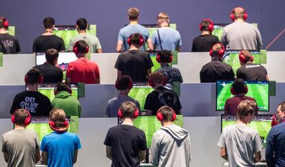 Un grupo de visitantes juega en parejas a un videojuego de fútbol.