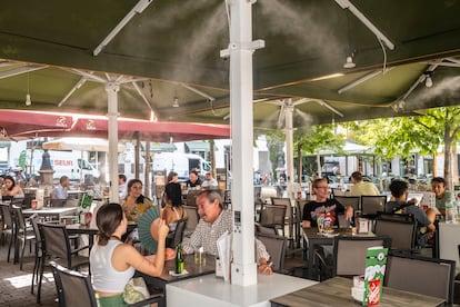 Una terraza de la plaza Santa Ana con ventiladores y dispensadores de agua para apaciguar la ola de calor, este lunes en Madrid.