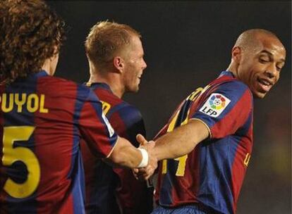 Puyol felicita a Henry por el gol