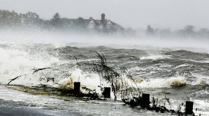 Agua conducida en una carretera por el huracán Sandy saltos sobre una barrera de seguridad en Southampton, Nueva York