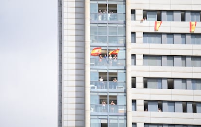 Varias personas con banderas de España en sus balcones durante la parada militar en Santa Cruz de Tenerife.