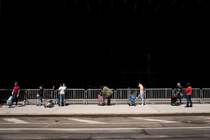 People wait in line in Brooklyn for care packages from a food bank.