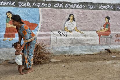 Una mujer y su hija frente a uno de las pinturas que en el pueblo de Pendlimanu se utilizan para educar a los habitantes sobre los hábitos más saludables. Como ir a un médico cuando alguien está enfermo, y no a un chamán.