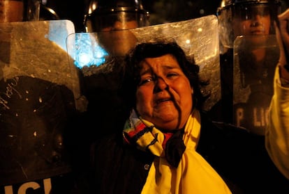 Partidária do candidato Guillermo Lasso, diante da polícia, em Quito.