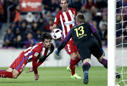 El portero holandés del FC Barcelona Jasper Cillessen se lanza a parar el remate de cabeza de defensa montenegrino del Atlético de Madrid Stefan Savic.