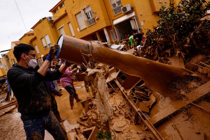 Un voluntario retira barro del exterior de una vivienda en Massanassa, este domingo. 