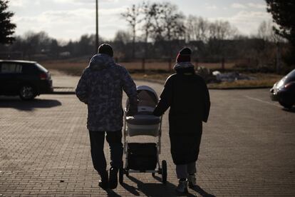 Alex y Maria, con el carrito de su bebé, el jueves frente al centro de acogida de refugiados en Hrubieszow (Polonia).