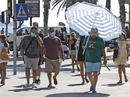 Un hombre se protege del sol en Alicante, en julio de 2022, durante una de las olas de calor que sufrió España el pasado verano.