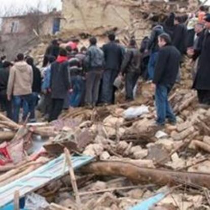 Varias personas buscan entre los escombros de una vivienda en Okcular, Turquía, después de que un terremoto de 6 grados de magnitud hoy