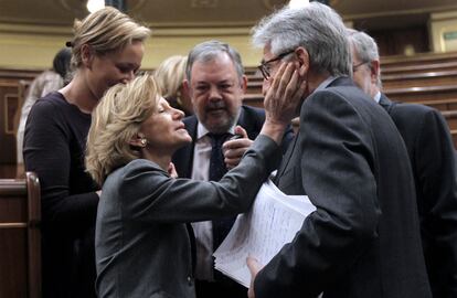 La ministra de Economía, Elena Salgado, acaricia a Josep Sánchez Llibre, de CiU, durante el pleno del Congreso.