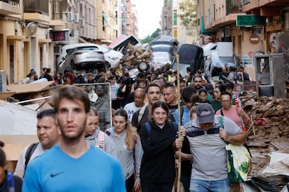 Decenas de jóvenes trabajan como voluntarios en labores de limpieza y de reparto de suministros en Alfafar (Valencia).