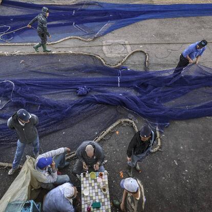 Un grupo de pescadores en torno a un té en el muelle.