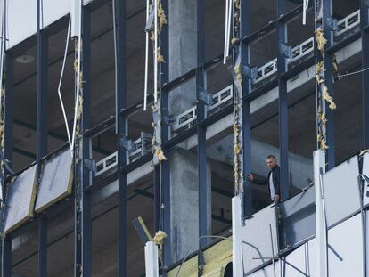 Un miembro de los servicios de seguridad investiga un edificio dañado tras un supuesto ataque con drones en Moscú, este lunes.