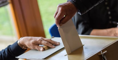 Mujer introduciendo su voto en una urna