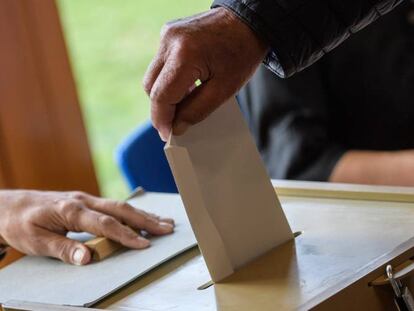 Mujer introduciendo su voto en una urna