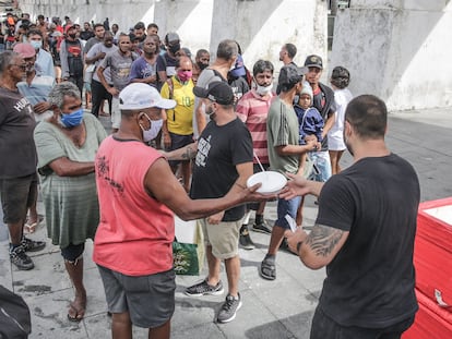Voluntários distribuem comida a pessoas pobres no Rio de Janeiro, em abril.