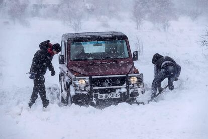 Dos hombres intentan sacar su vehículo atrapado en la nieve el lunes, en las proximidades de Yecla (Murcia).