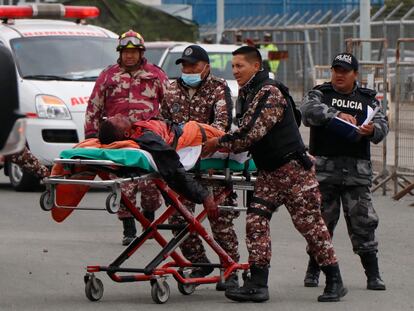 Guardias evacúan a un prisionero herido en el amotinamiento en la cárcel Cotopaxi en Latacunga, Ecuador, el 4 de octubre de 2022.