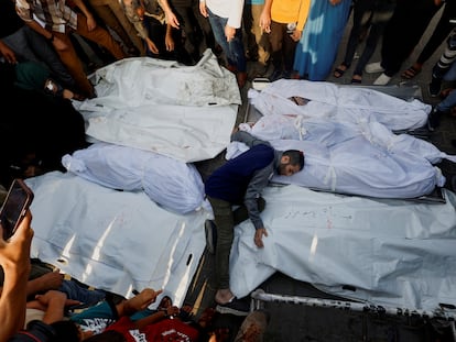 Un hombre coloca los cuerpos de las víctimas de un bombardeo israelí en Gaza durante un funeral en Jan Yunis, este martes.