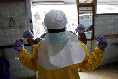 Un trabajador de salud se pone el equipo de protección contra el ébola antes de ingresar a la Unidad de Atención de Emergencia de Biosecure (CUBE) en el centro de tratamiento de Ébola ALIMA (Alianza para la Acción Médica Internacional) en Beni, en la República Democrática del Congo, el 31 de marzo de 2019.