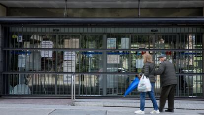 Dos personas frente al centro de salud Doctor Cirajas cerrado, este jueves en Madrid.