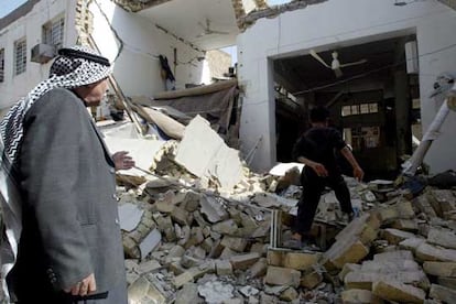 Dos personas observan los escombros de la mezquita suní en el barrio Al-Huraya de Bagdad, que ha sido destruida por las bombas.