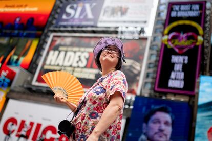 A tour guide fans herself while working in Times Square as temperatures rise, July 27, 2023, in New York.