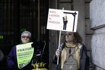 Dos mujeres afectadas por las preferentes se manifiestan ante la sede de Bankia situada en el número 1 de la calle Alcalá, próxima a la Puerta del Sol, en Madrid. EFE/Archivo