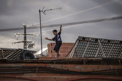 Un niño juega en el tejado de su casa, lleno de paneles solares, en el sector 6. Muchos vecinos han instalado paneles para tener algo de electricidad, aunque normalmente no suele ser suficiente para alimentar a todos los electrodomésticos.
